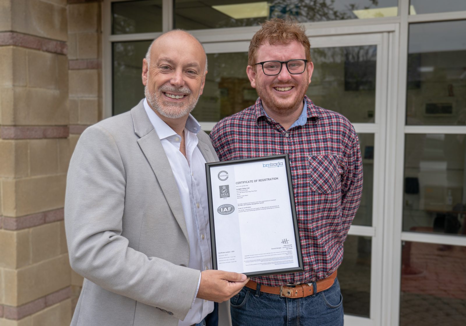 andrew scott and alex tremlett holding the ISO 9001 certificate